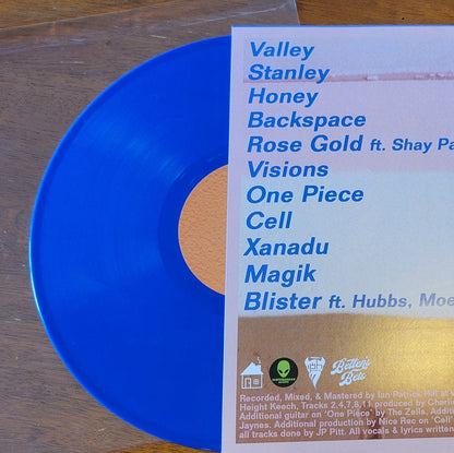 Blue vinyl record with a white label on a wooden surface