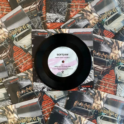 A black 7-inch vinyl record labeled 'SOFTJAW' with a barcode, surrounded by various album covers.