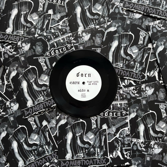 Vinyl record with a black label on top of a collage of album covers featuring a band.