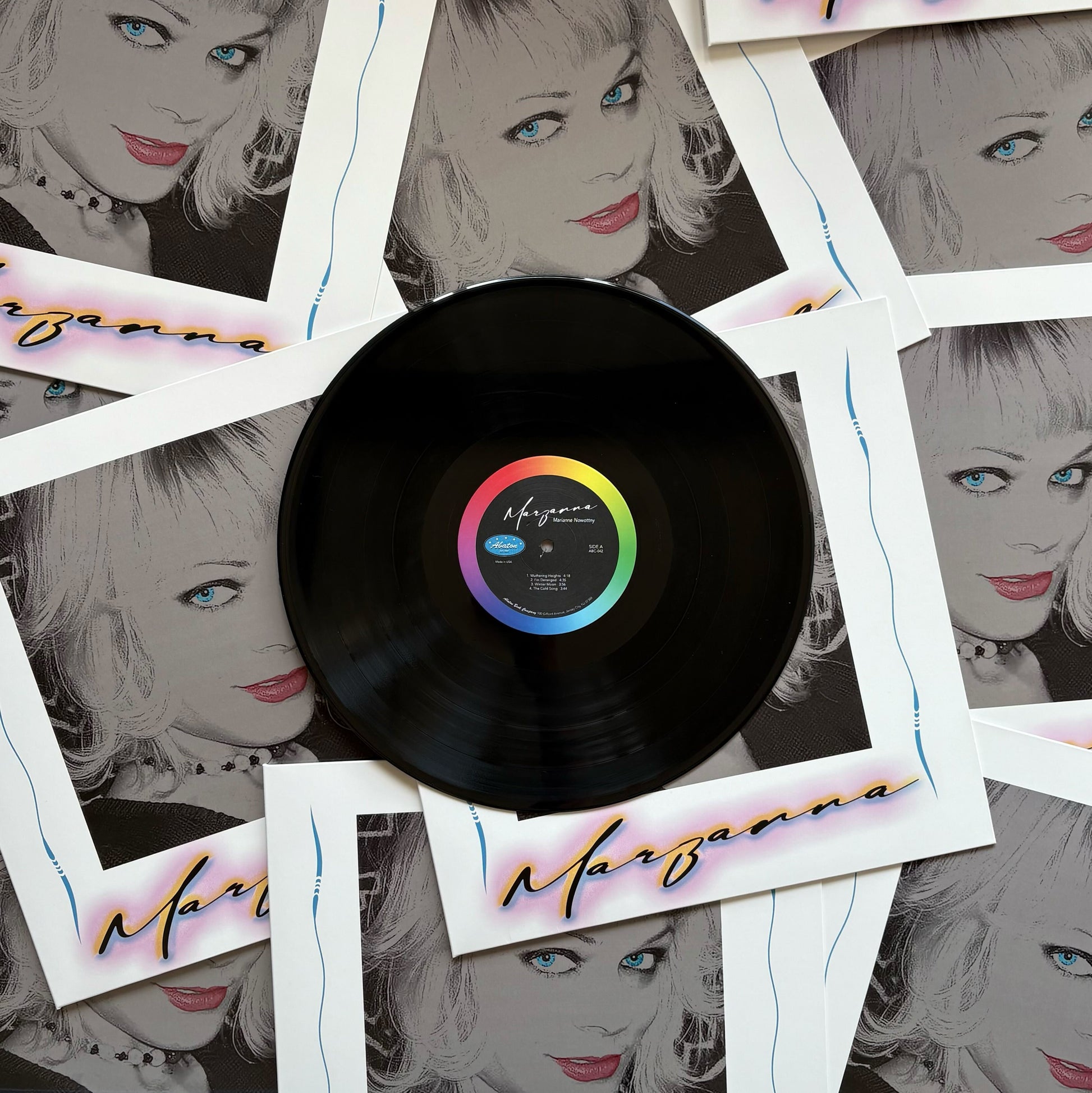 Vinyl record with a colorful label surrounded by Polaroid-style images of a woman's face.