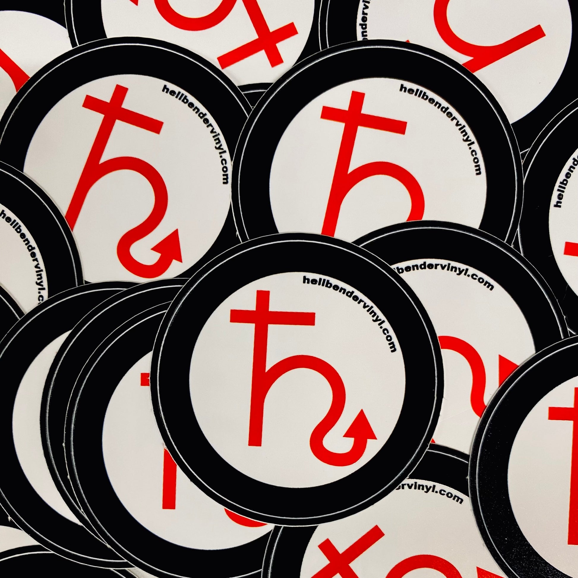 Stack of circular stickers with a red symbol and website text on a white background