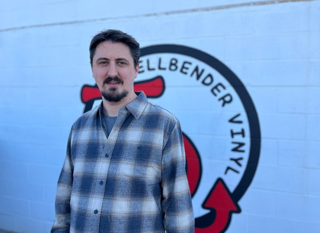 Man standing in front of a vehicle with 'Hellbender Vinyl' branding